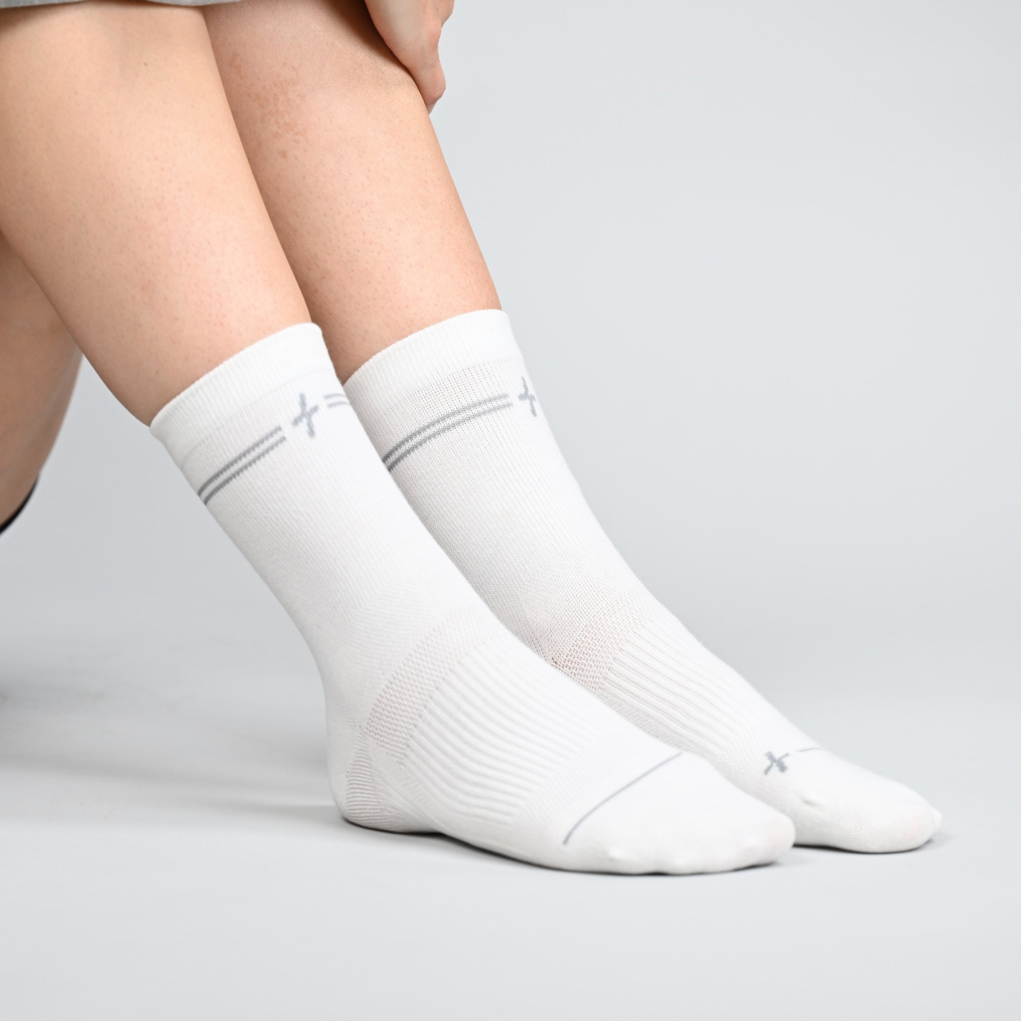 White socks worn by a person on a light gray background