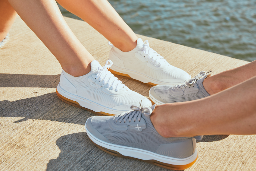 A gray and white pair of shoes featured near the water